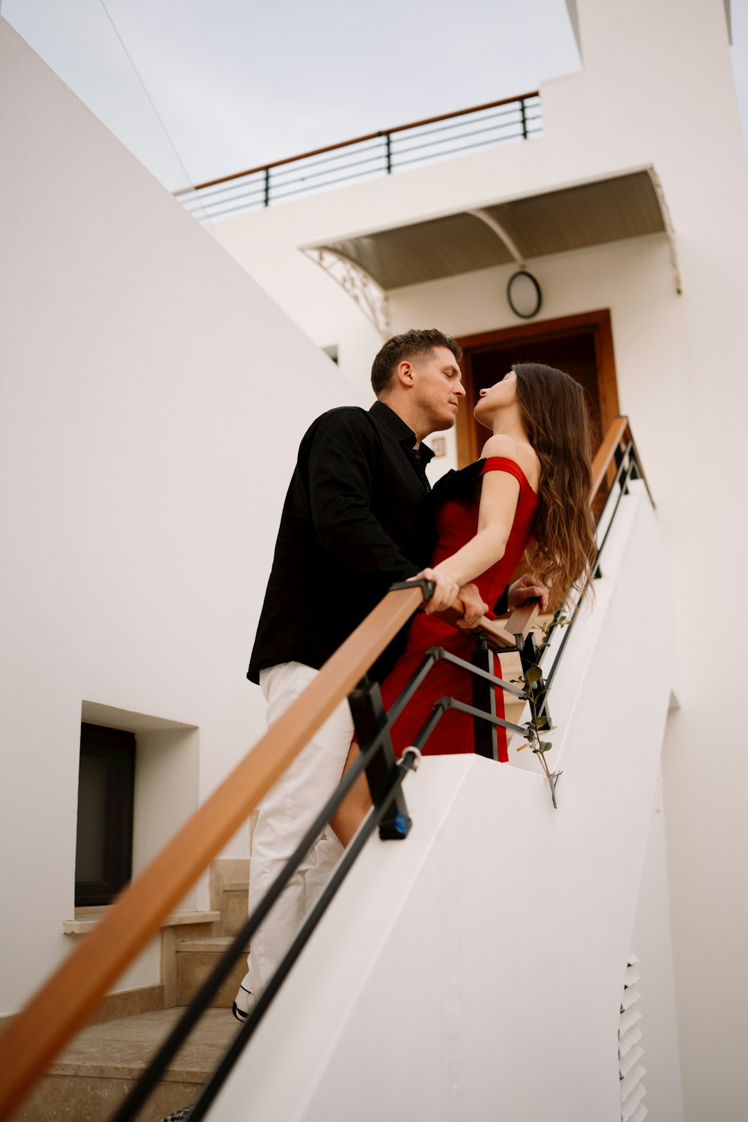 a-couple-embracing-on-a-white-staircase-edw6m77qopu