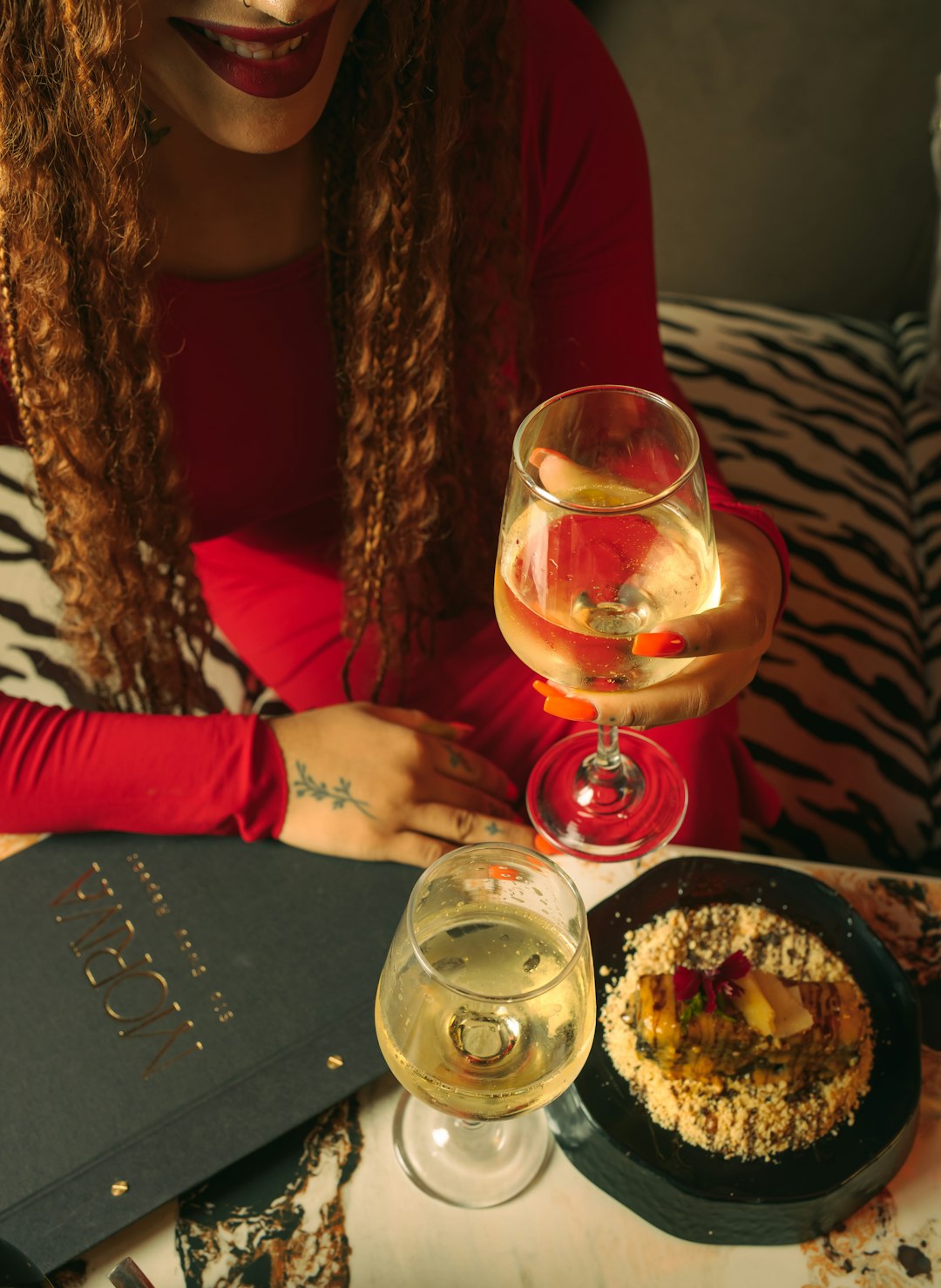 woman-in-red-holding-wine-glass-with-food-j3bvrnttsvm